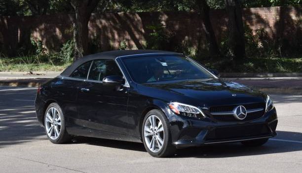 Luxury Mercedes S-Class with chauffeur parked in London’s business district.
