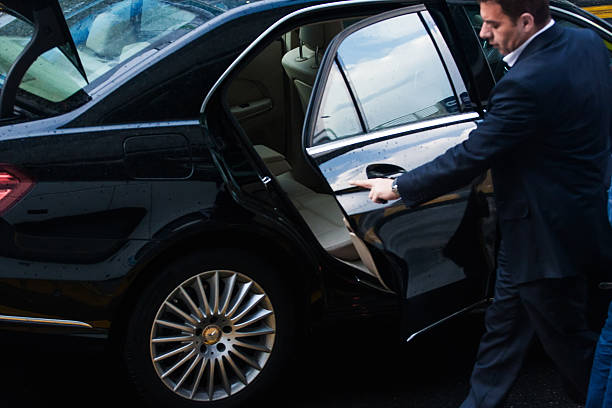Luxury black limousine parked in central London near iconic landmarks.